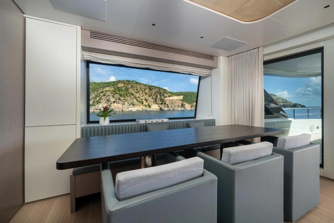 a room with a large window and a large table with chairs aboard SEAESTA Yacht for Sale