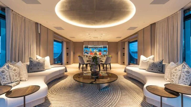 a living room with a large white couch and a large window aboard SEAESTA Yacht for Sale
