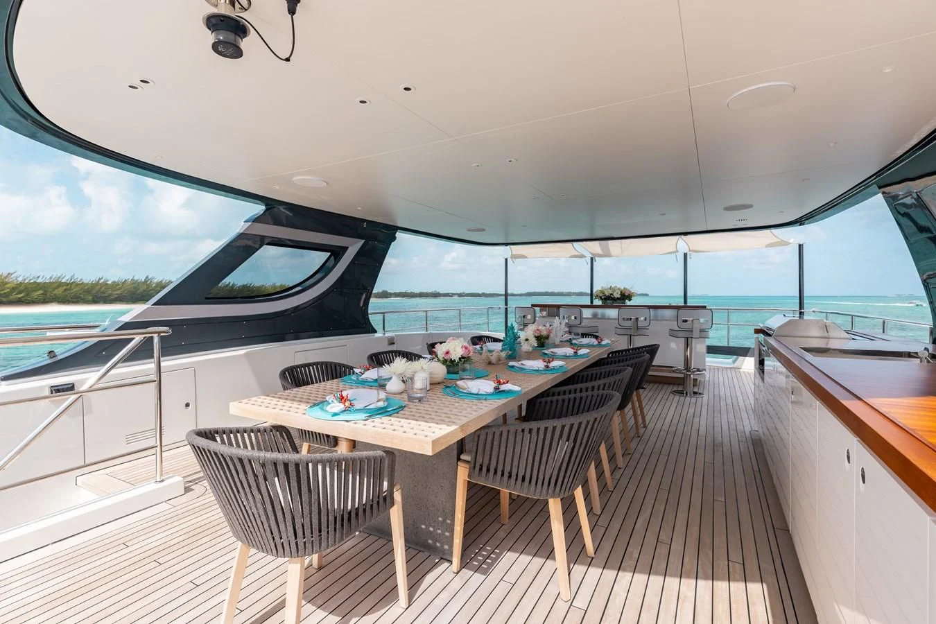 a large open space with a table and chairs and a view of the ocean aboard SEAESTA Yacht for Sale