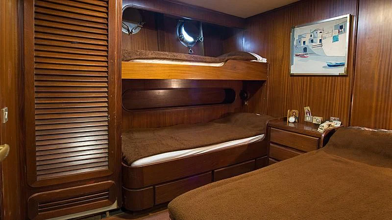 a room with a bed and a dresser aboard ATHINA Yacht for Sale