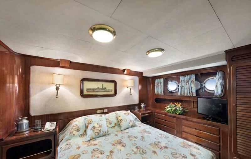 a bedroom with a bed and a television aboard ATHINA Yacht for Sale