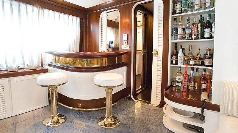 a room with a table and stools and bottles of liquor aboard ATHINA Yacht for Sale