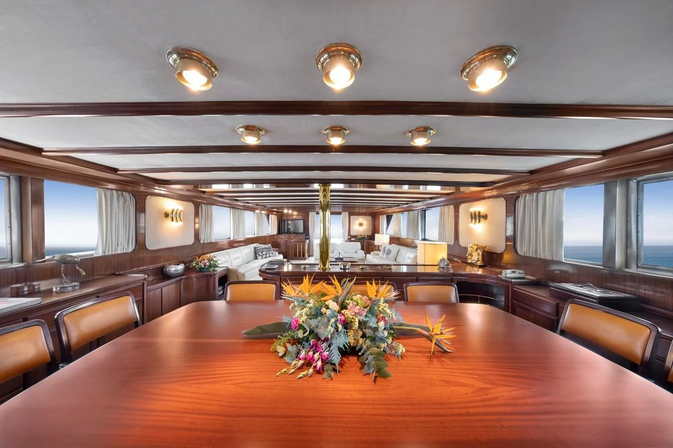 a large room with a wood table and chairs aboard ATHINA Yacht for Sale