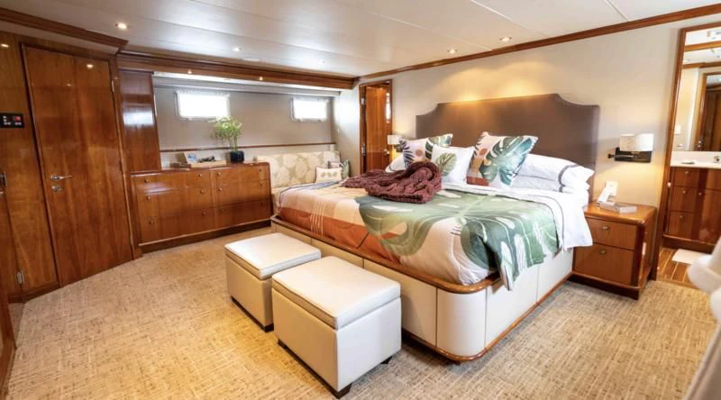 a bedroom with a bed and a desk aboard WELL DONE Yacht for Sale