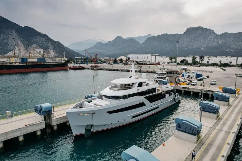 a large white boat sits at a dock aboard HEEUS Yacht for Sale
