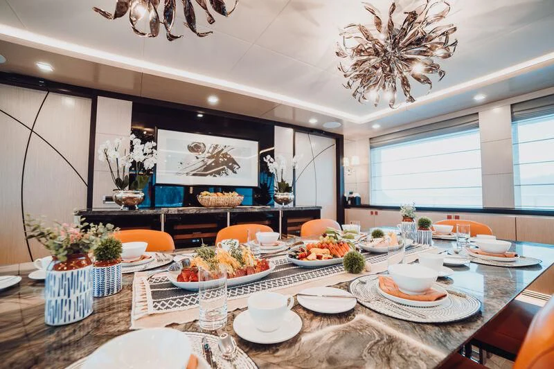 a large table with plates and food on it aboard HEEUS Yacht for Sale