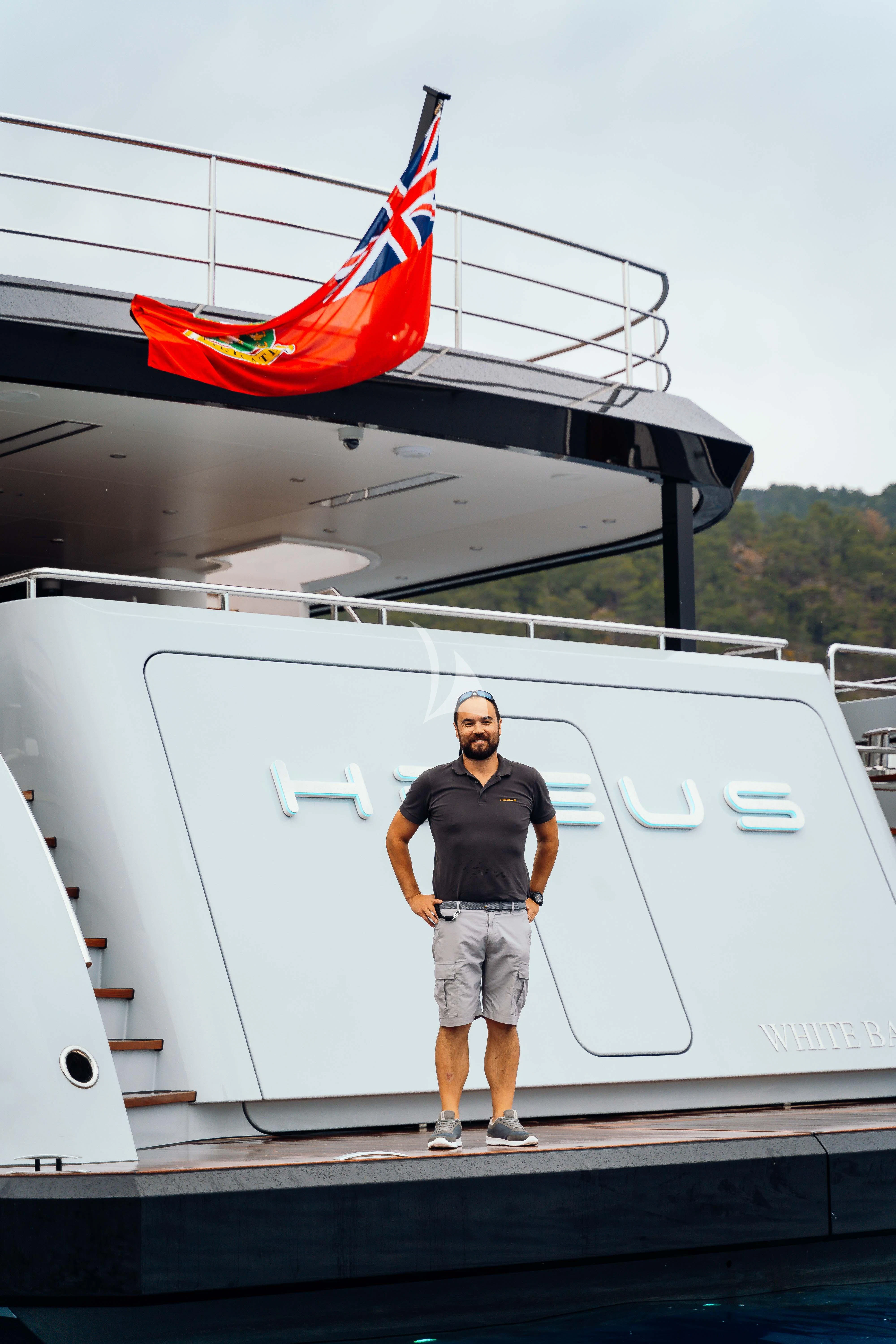 a man standing on a boat aboard HEEUS Yacht for Sale