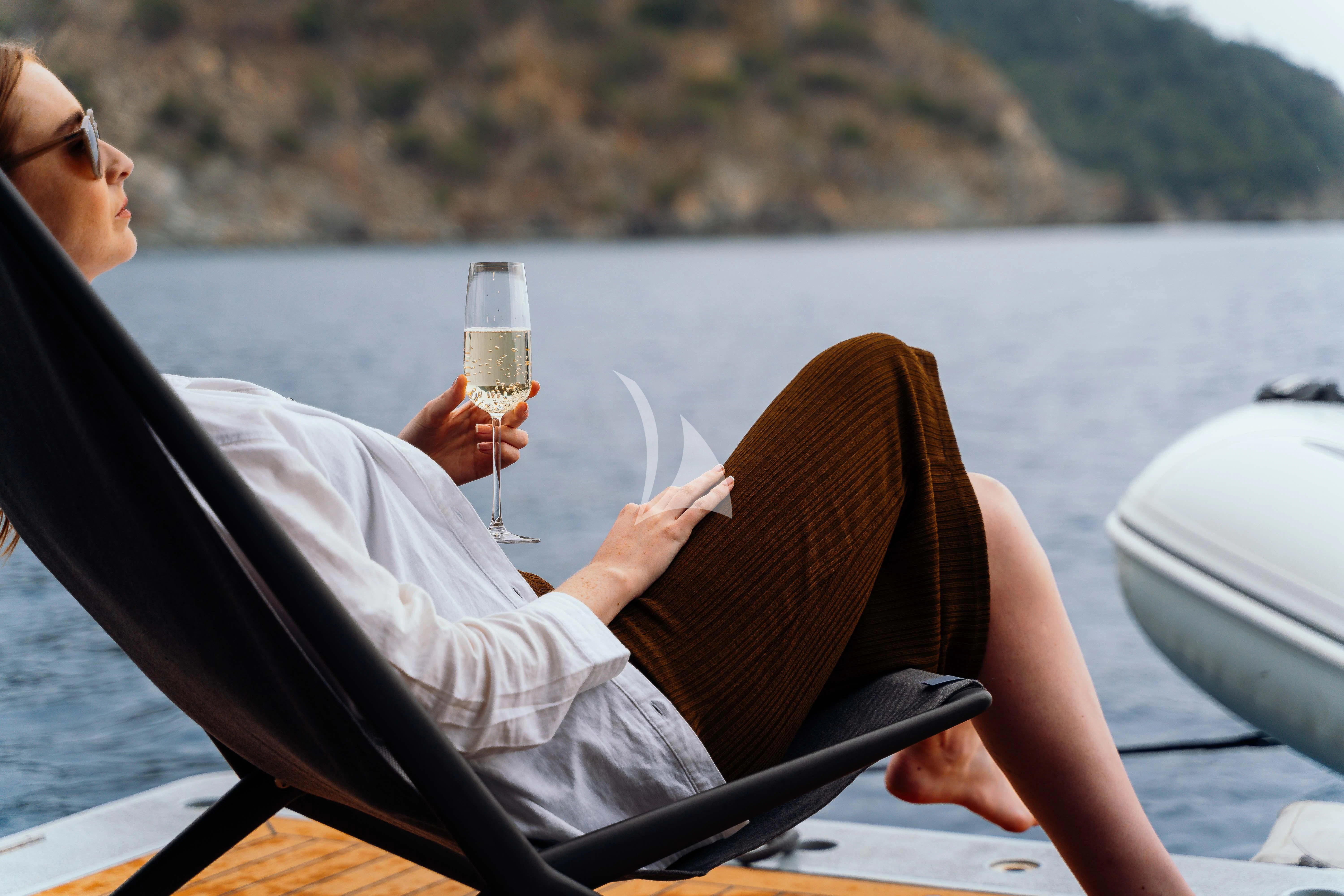 a woman holding a glass of wine aboard HEEUS Yacht for Sale