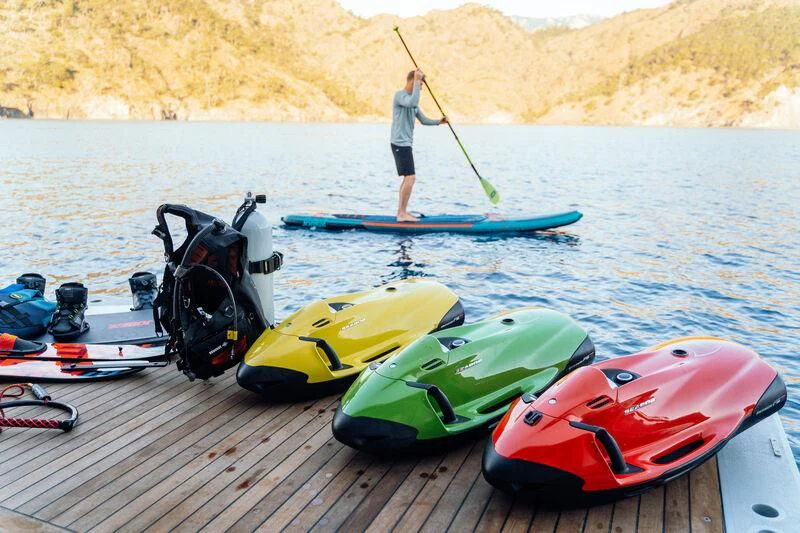 a person standing on a dock next to kayaks aboard HEEUS Yacht for Sale