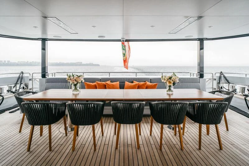 a table with chairs and a large window overlooking a body of water aboard HEEUS Yacht for Sale