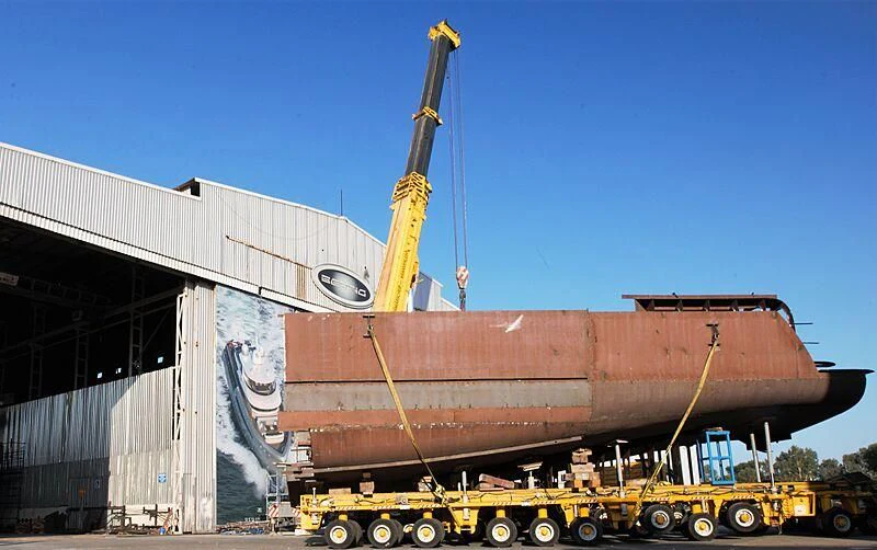 a large yellow crane next to Titanic Museum aboard HEEUS Yacht for Sale
