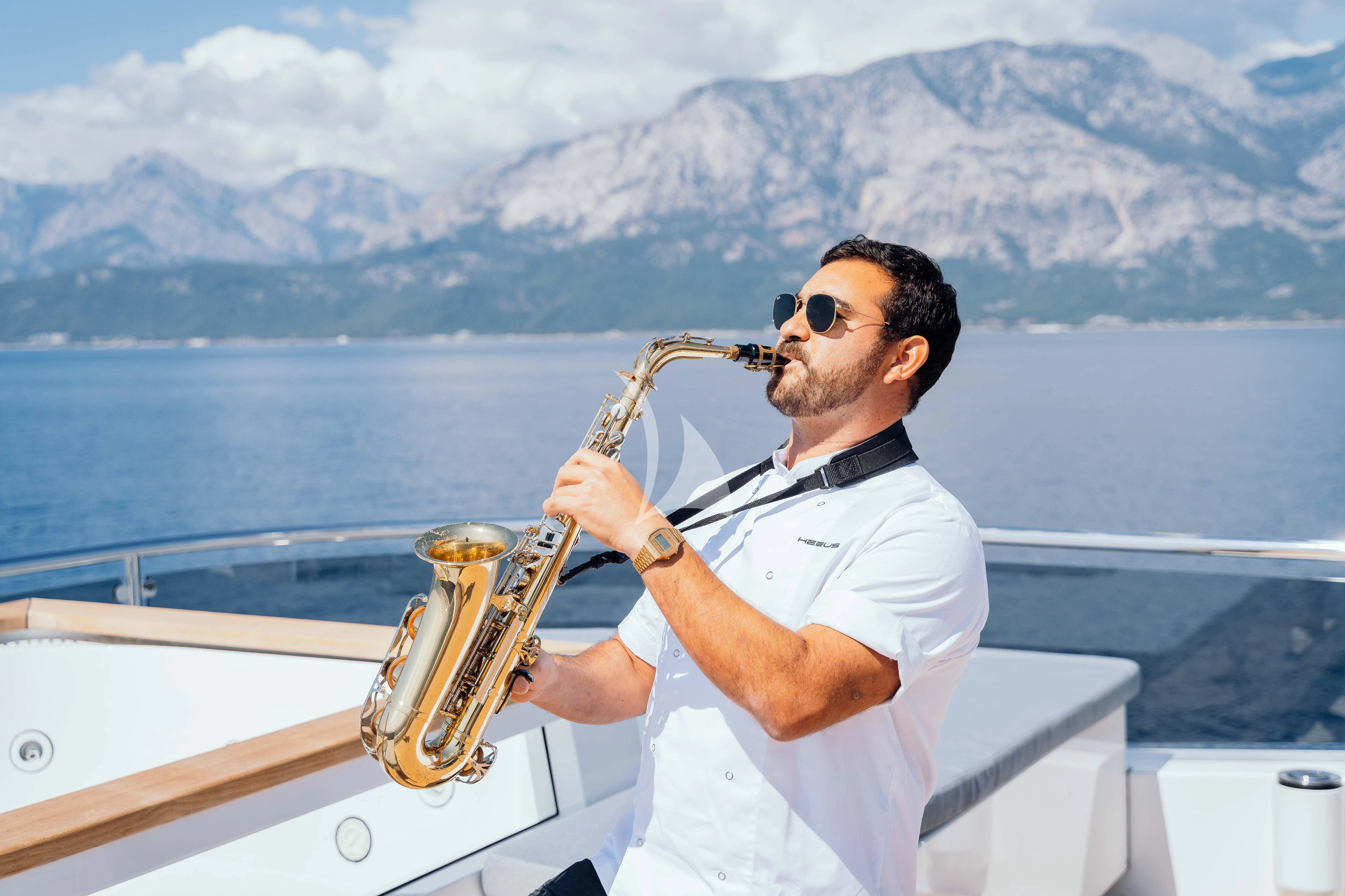 a man playing a trumpet on a boat aboard HEEUS Yacht for Sale