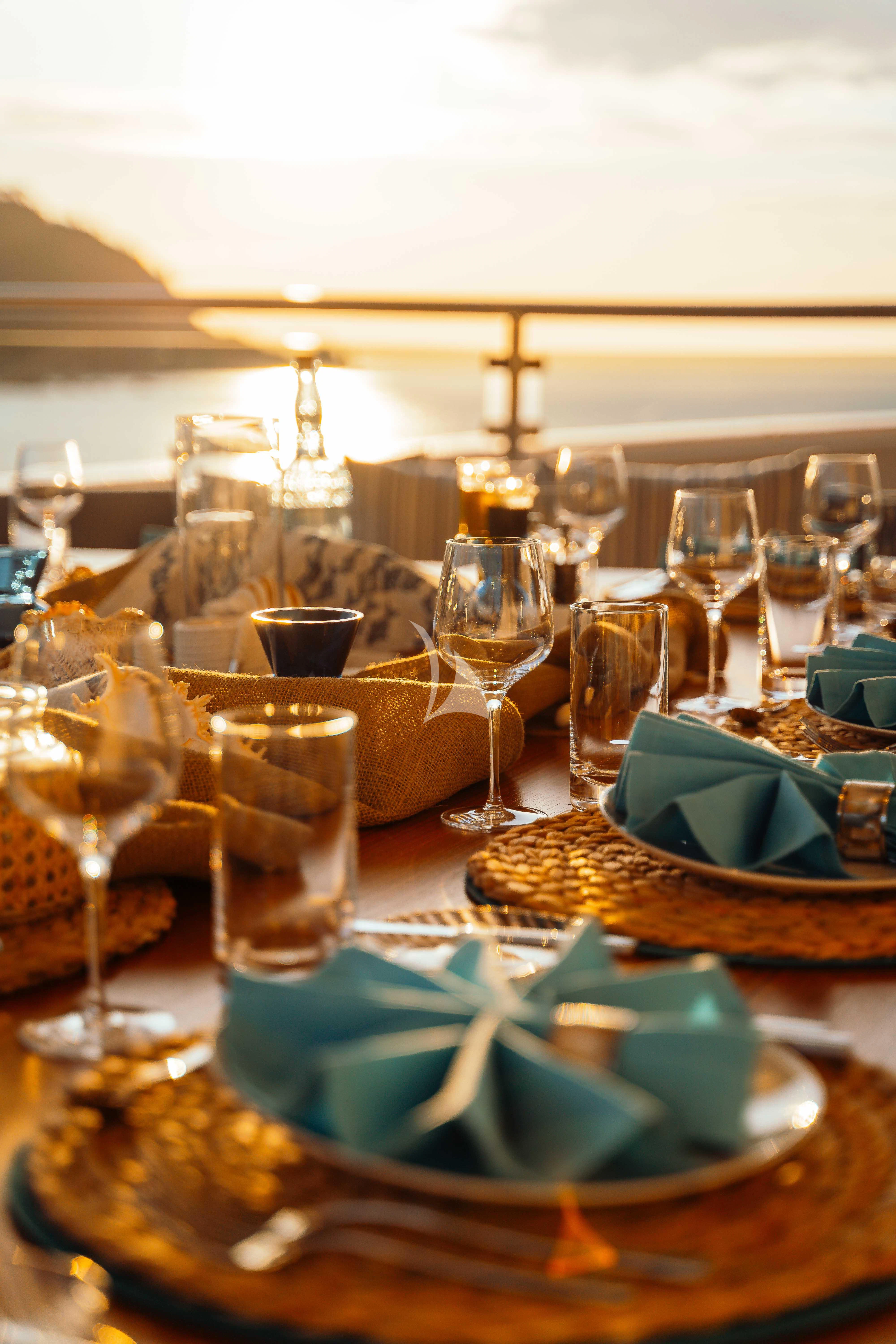 a table with glasses and plates of food on it aboard HEEUS Yacht for Sale