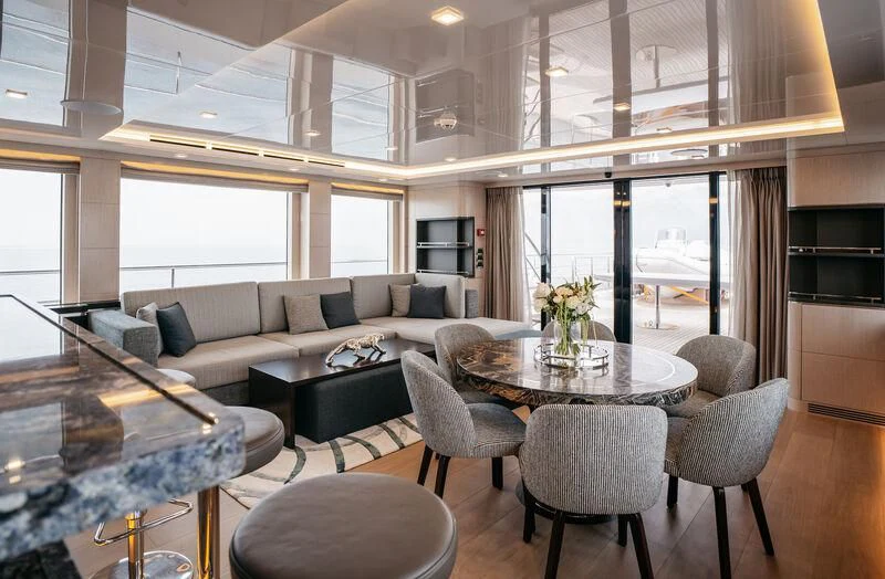 a living room with a large glass table and a couch aboard HEEUS Yacht for Sale