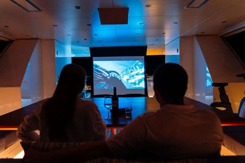 a man and woman watching a television aboard HEEUS Yacht for Sale
