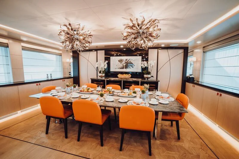 a large dining room with a chandelier aboard HEEUS Yacht for Sale
