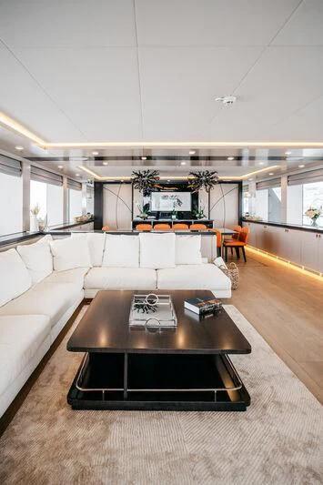 a living room with a table and couches aboard HEEUS Yacht for Sale