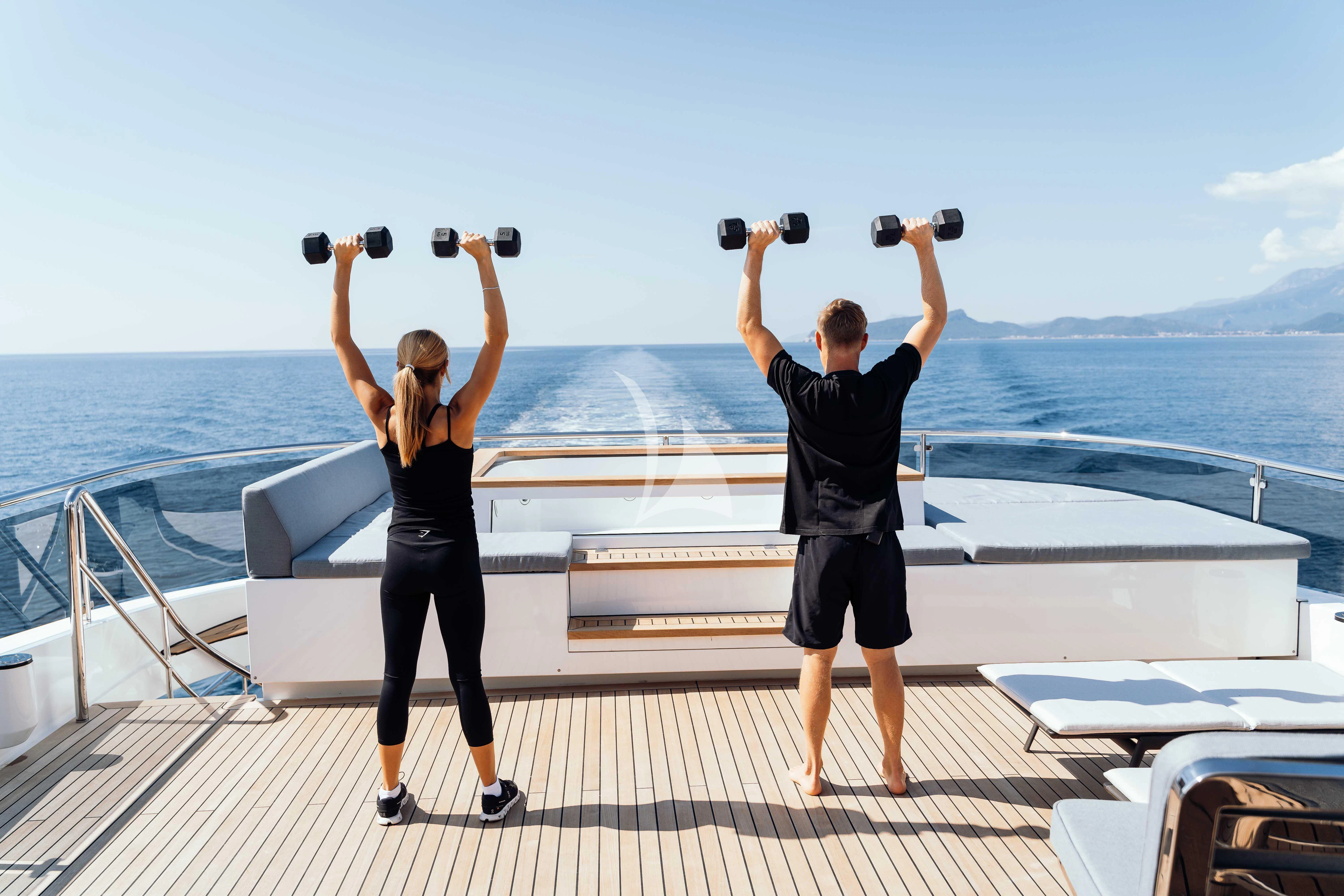 a man and woman holding binoculars on a boat aboard HEEUS Yacht for Sale