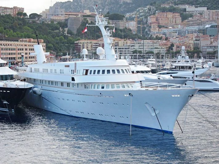 a large white boat in a harbor aboard ATLANTIS II Yacht for Sale