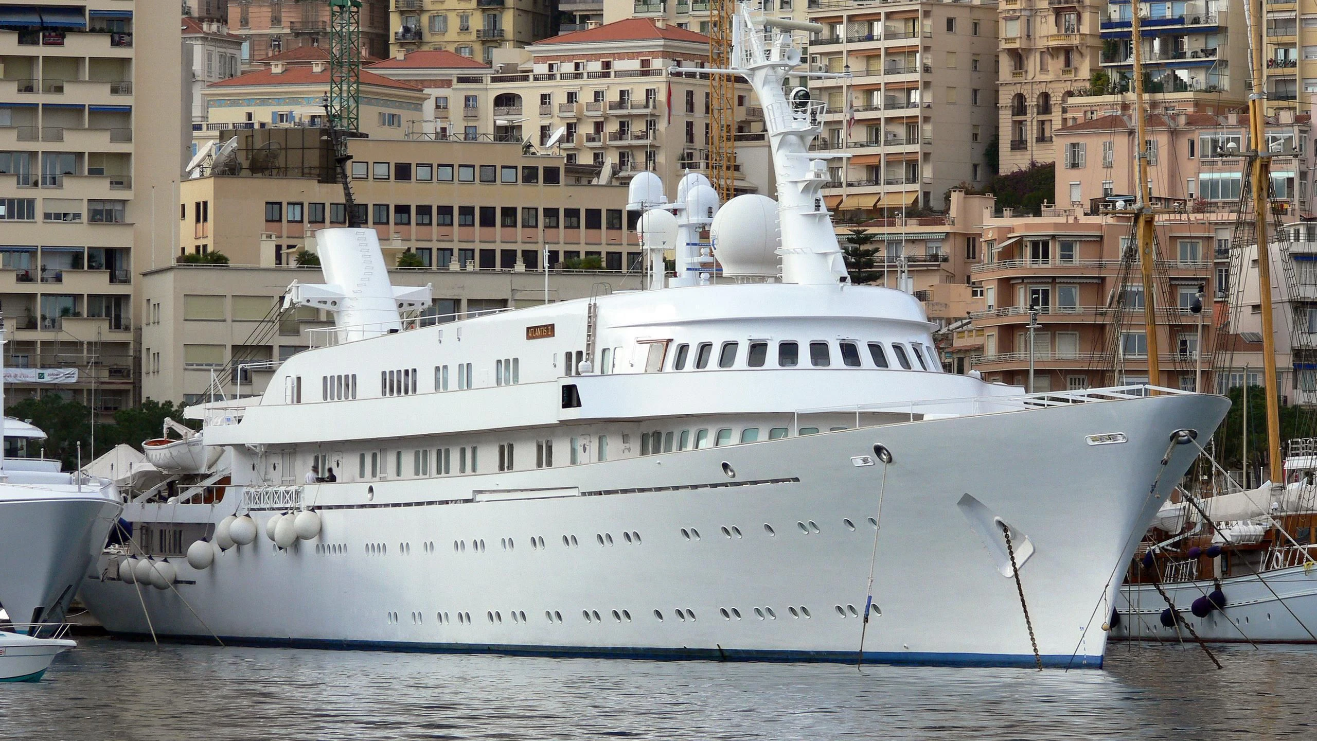 a large white boat in a harbor aboard ATLANTIS II Yacht for Sale