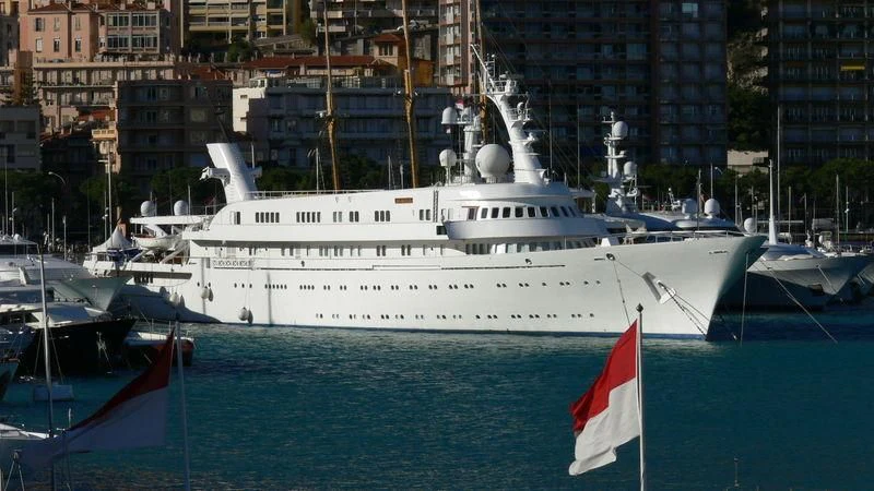 a large white boat in a harbor aboard ATLANTIS II Yacht for Sale