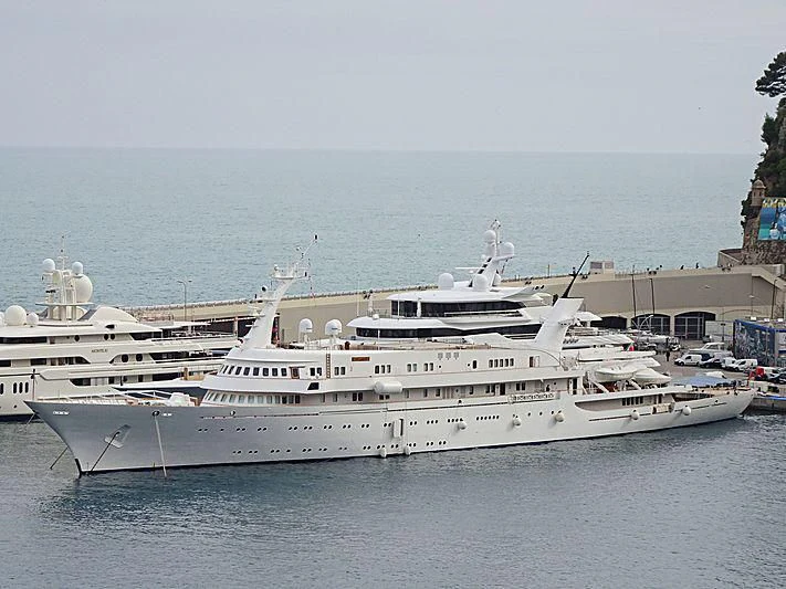 a large white boat in a harbor aboard ATLANTIS II Yacht for Sale