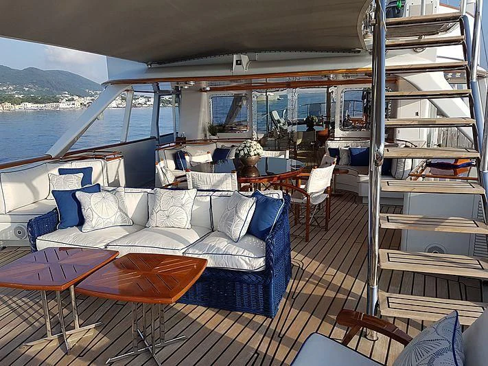 a boat with a deck and a table and chairs on it aboard MIKADO Yacht for Sale