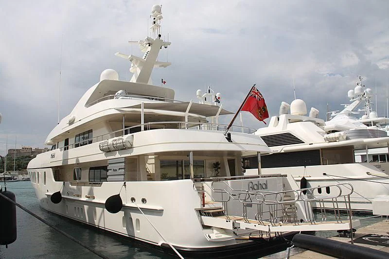 a large white boat with a flag on the front aboard RAHAL Yacht for Sale