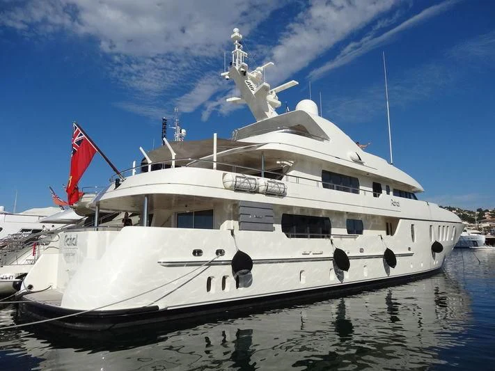 a boat with a flag on the front aboard RAHAL Yacht for Sale