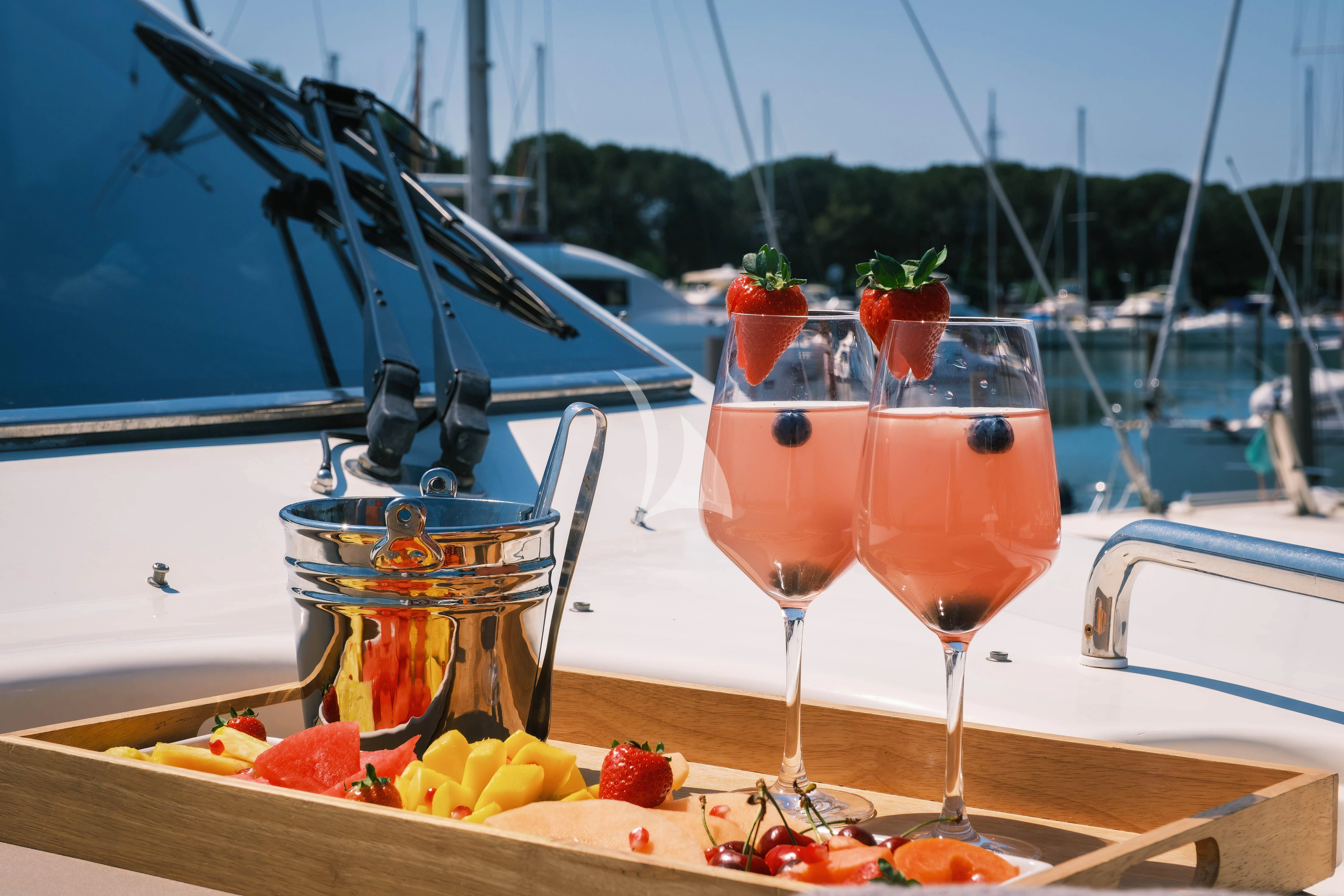 a group of glasses of wine on a table with a tray of fruit aboard MAGIC SIX Yacht for Sale