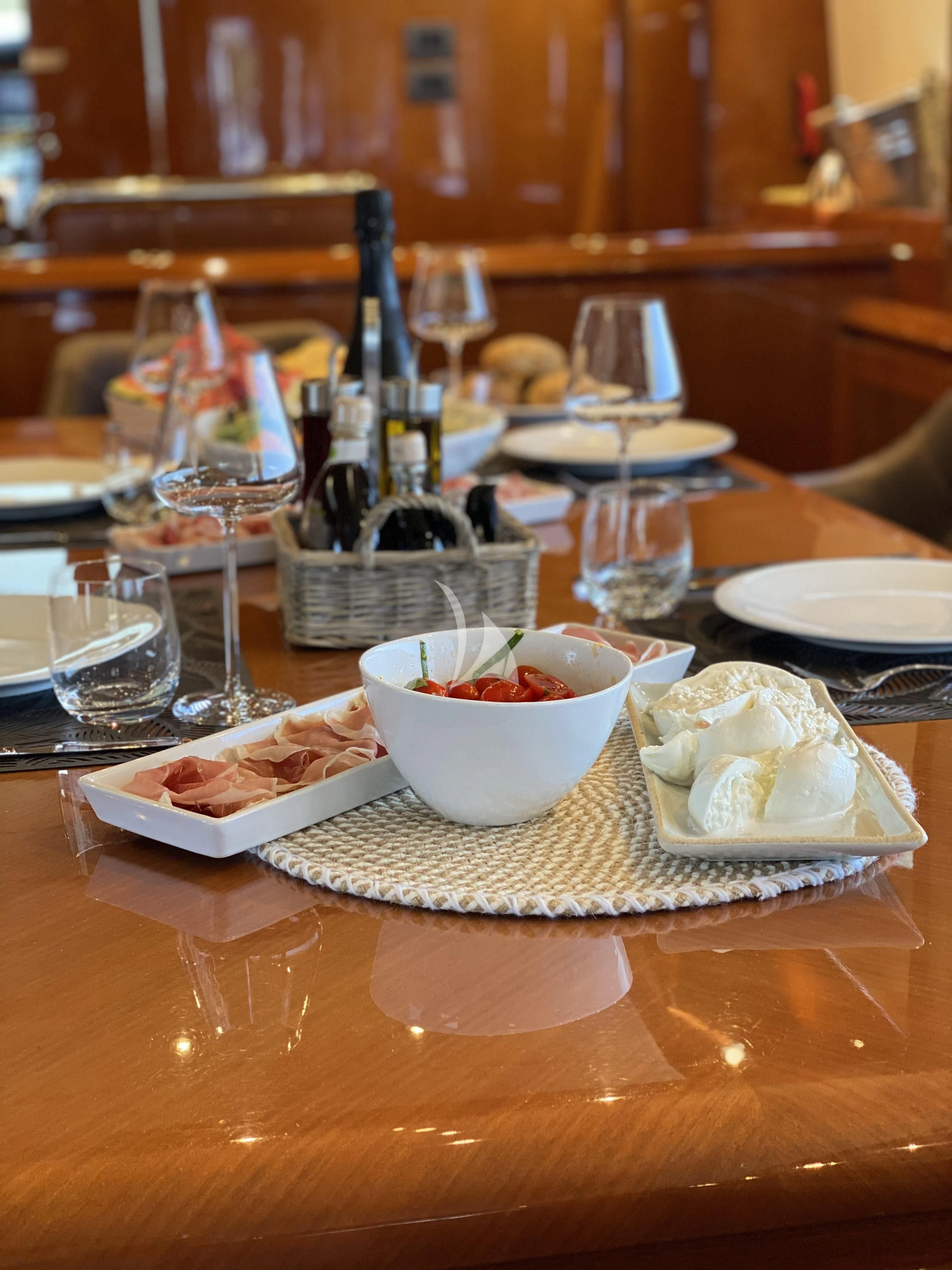 a table with food and glasses on it aboard MAGIC SIX Yacht for Sale