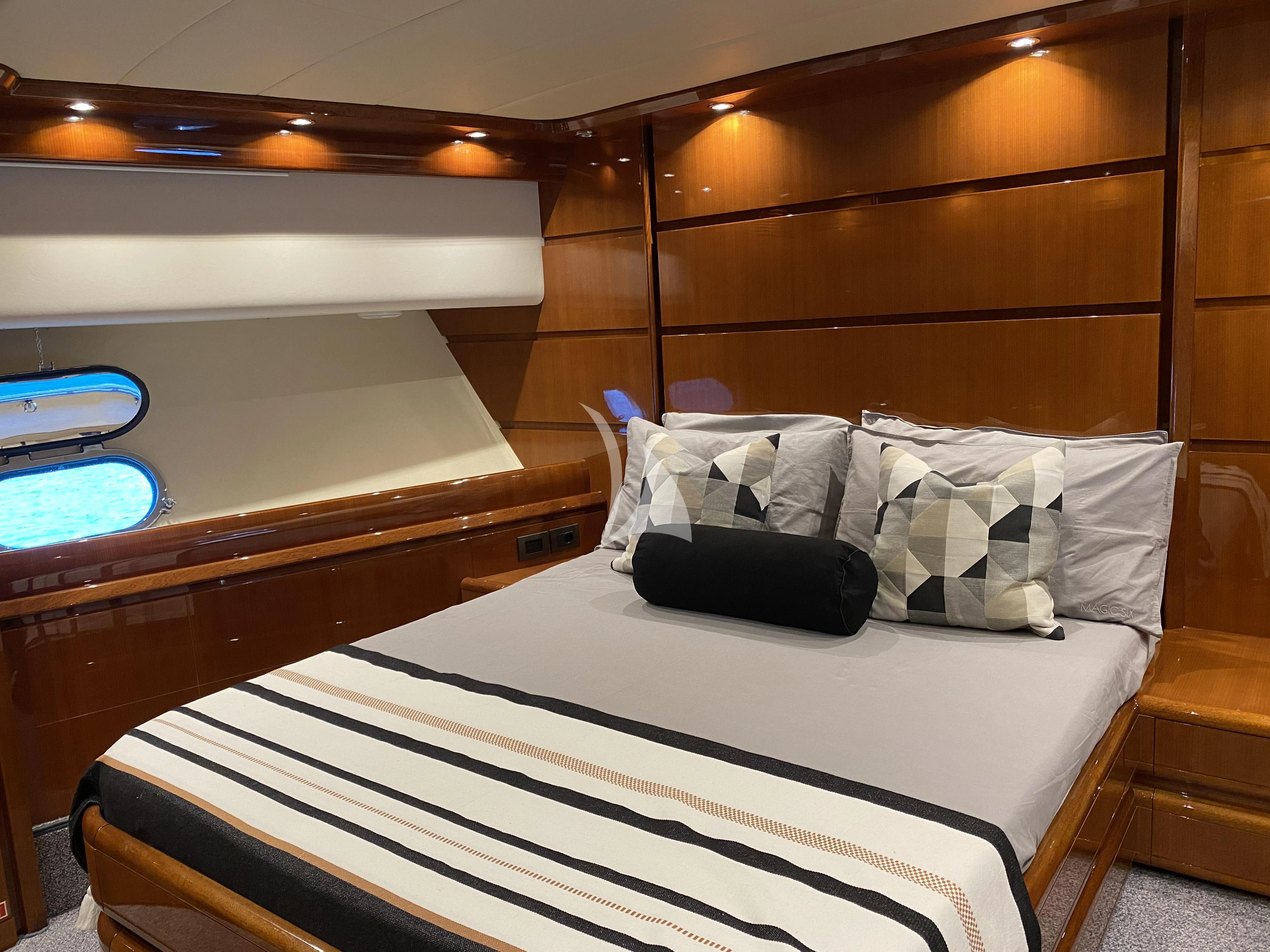 a bed with a black and white striped pillow on it aboard MAGIC SIX Yacht for Sale