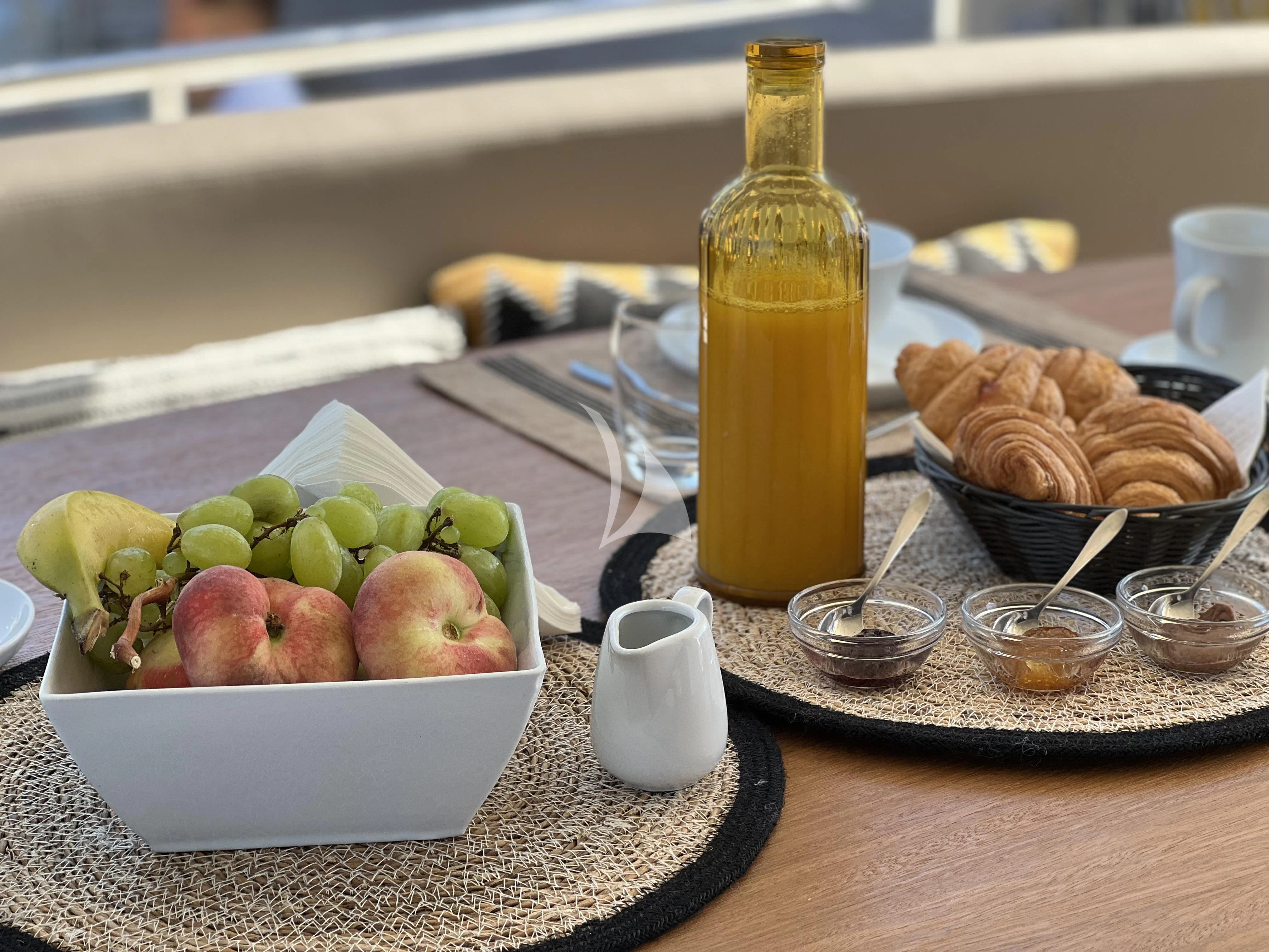 a bowl of fruit and a bottle of liquor on a table aboard MAGIC SIX Yacht for Sale