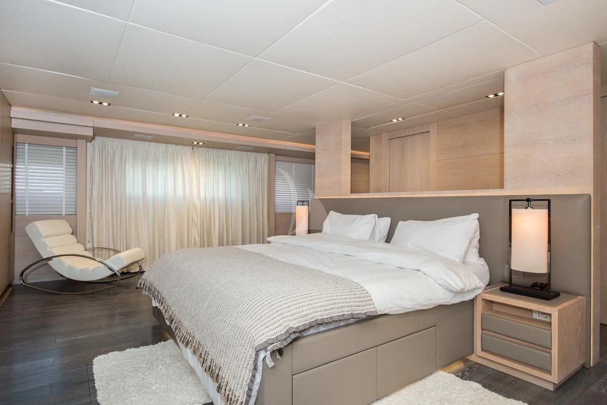 a bedroom with a bed and a chair aboard FAST & FURIOUS Yacht for Charter