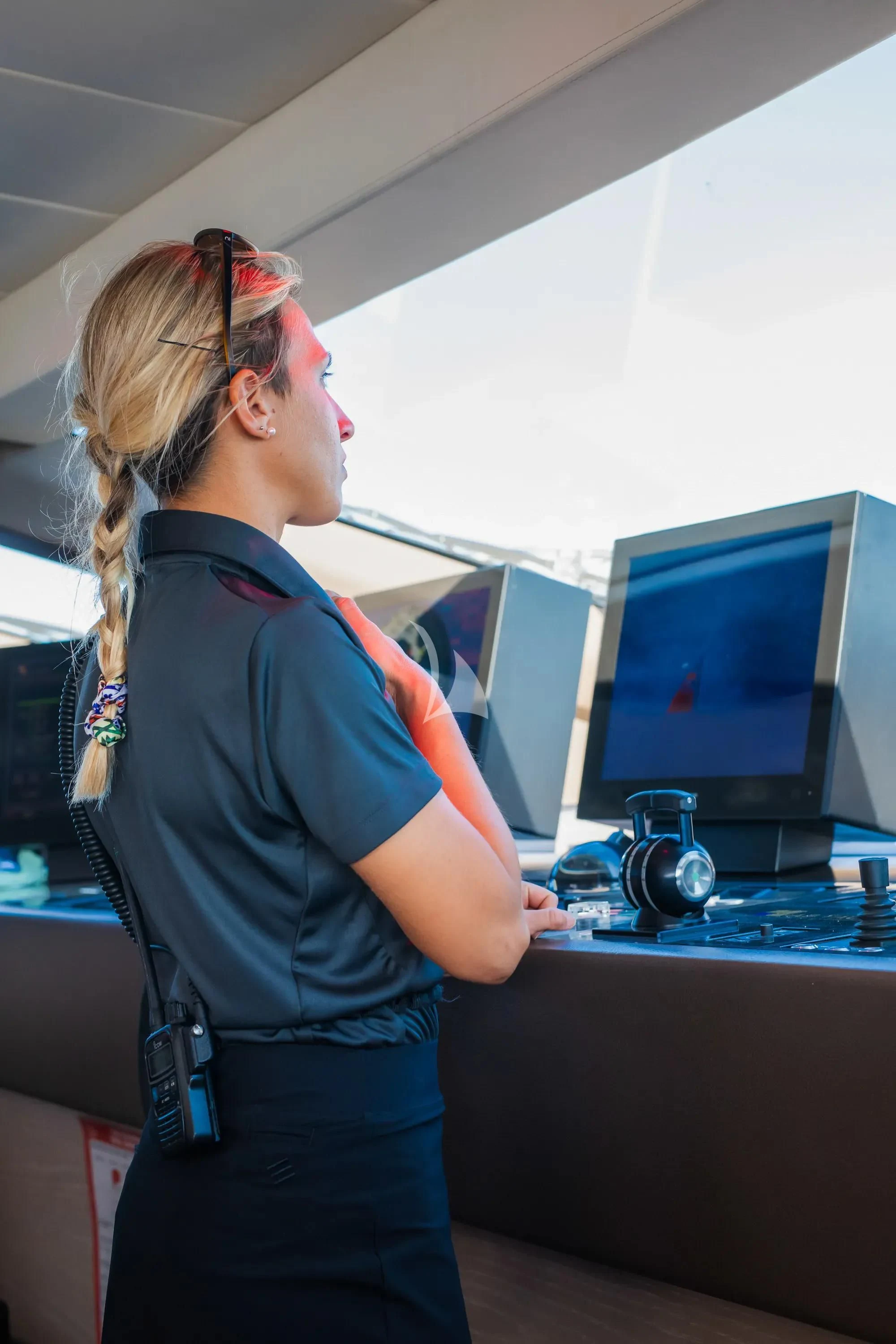 a person wearing a blue shirt and black pants standing in front of a computer aboard FAST & FURIOUS Yacht for Charter
