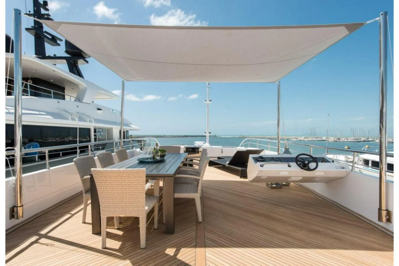 a deck with a table and chairs on it aboard FAST & FURIOUS Yacht for Charter