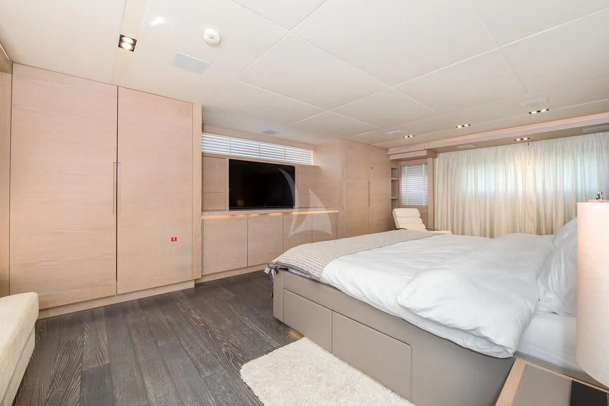 a room with a bed and a television aboard FAST & FURIOUS Yacht for Charter