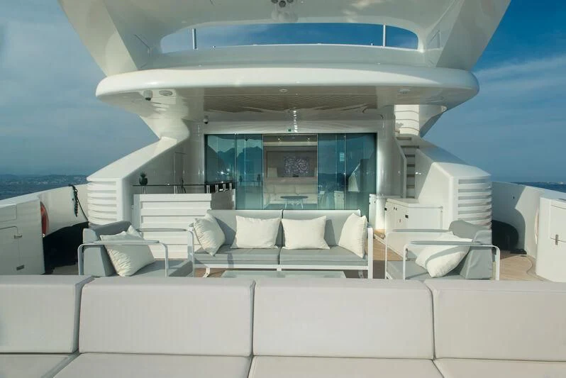 a room with a white couch and a large window aboard FAST & FURIOUS Yacht for Charter
