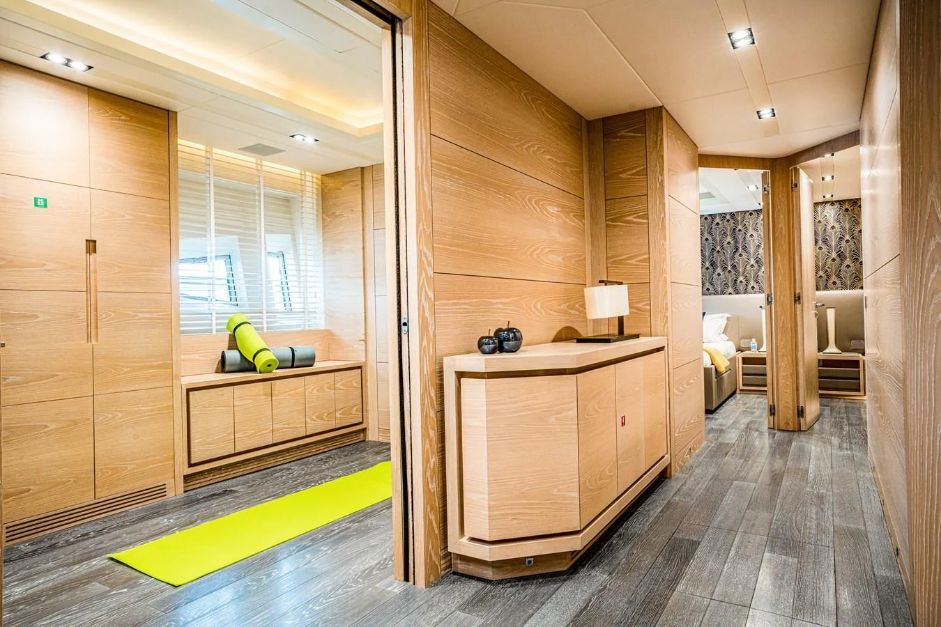 a room with a wood floor and a wood cabinet and a shelf with a lamp and a window aboard FAST & FURIOUS Yacht for Charter