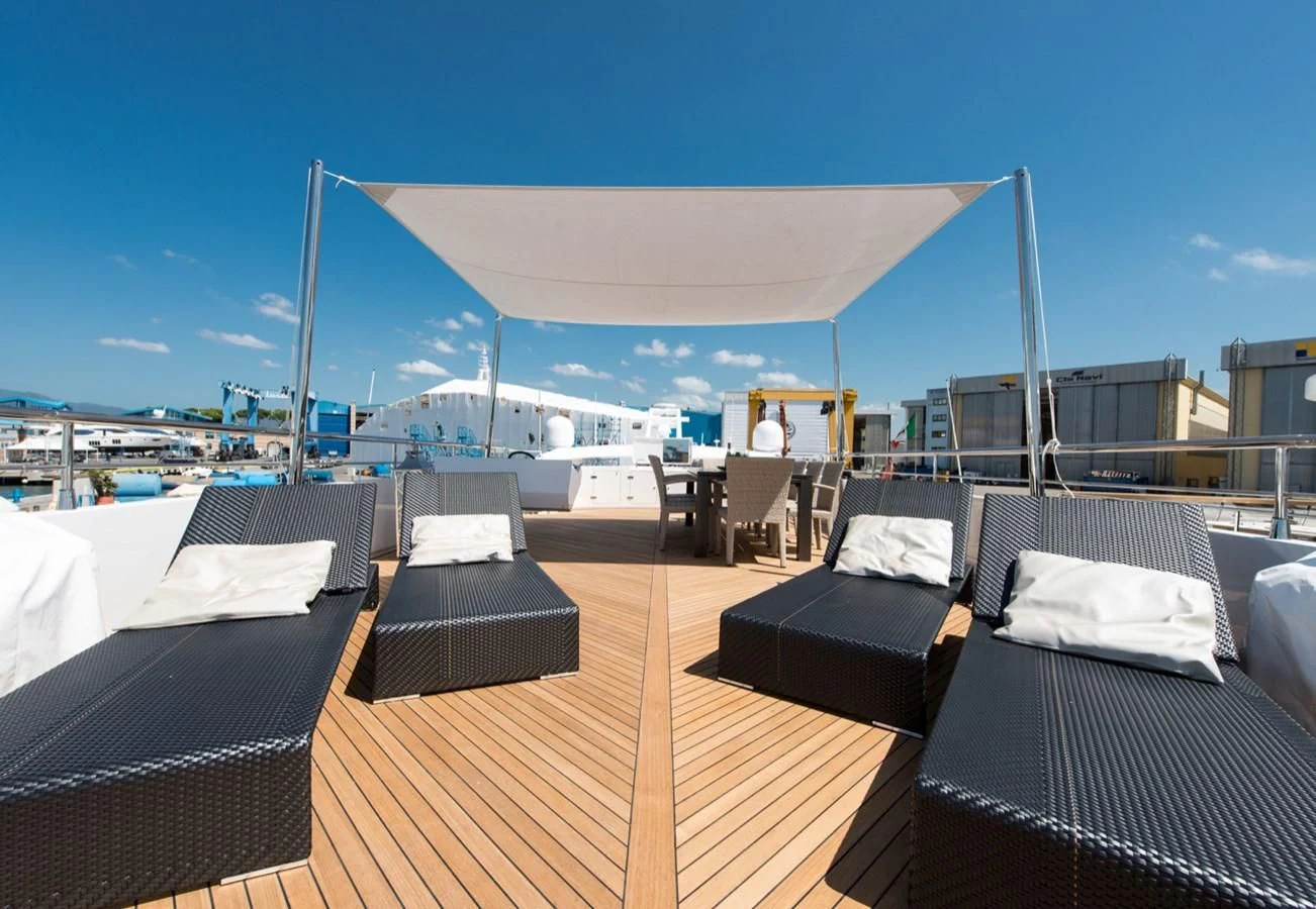 a deck with a view of the ocean and a large building aboard FAST & FURIOUS Yacht for Charter