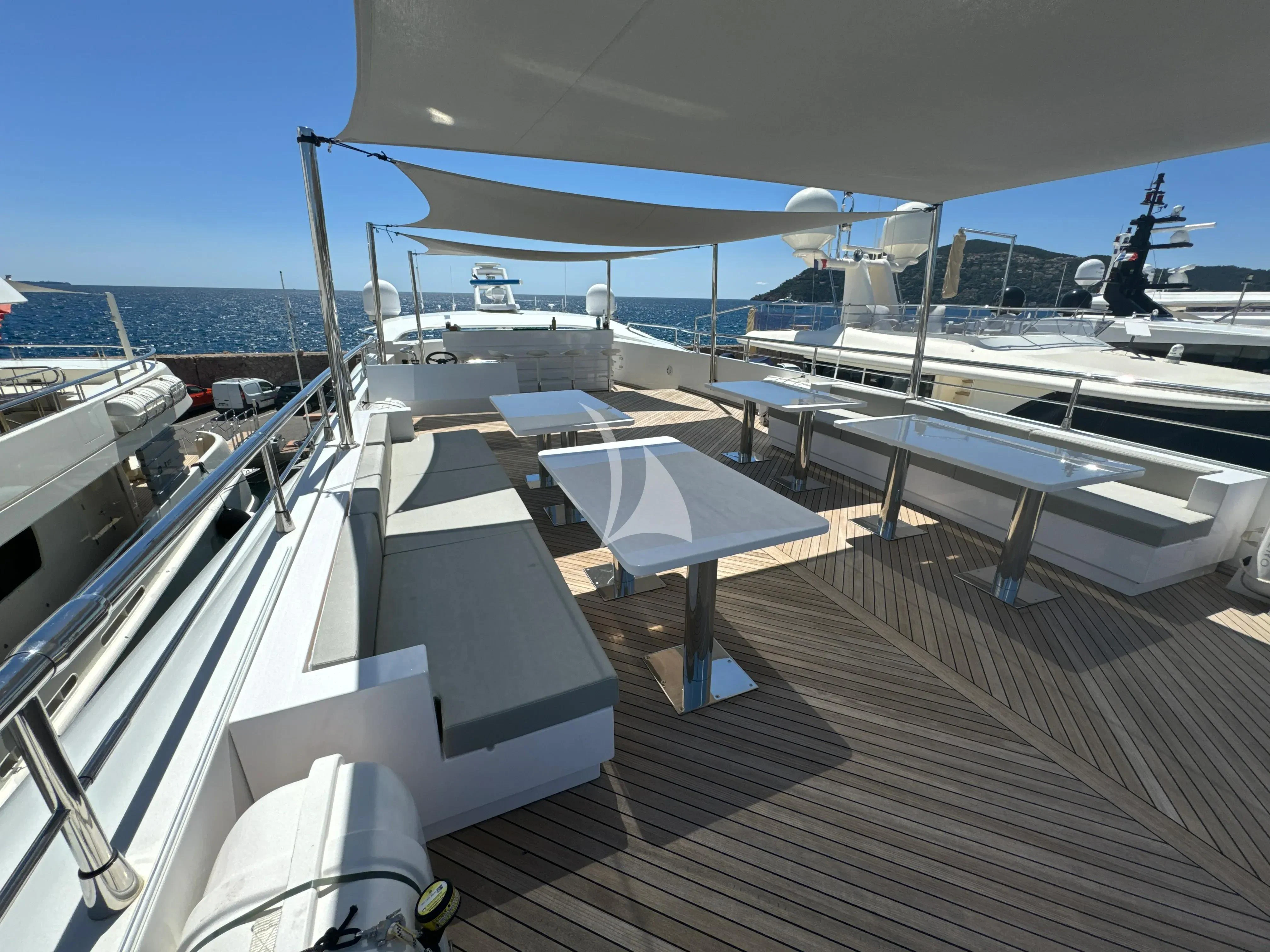 a deck with a boat and a deck with a railing and a blue sky aboard FAST & FURIOUS Yacht for Charter
