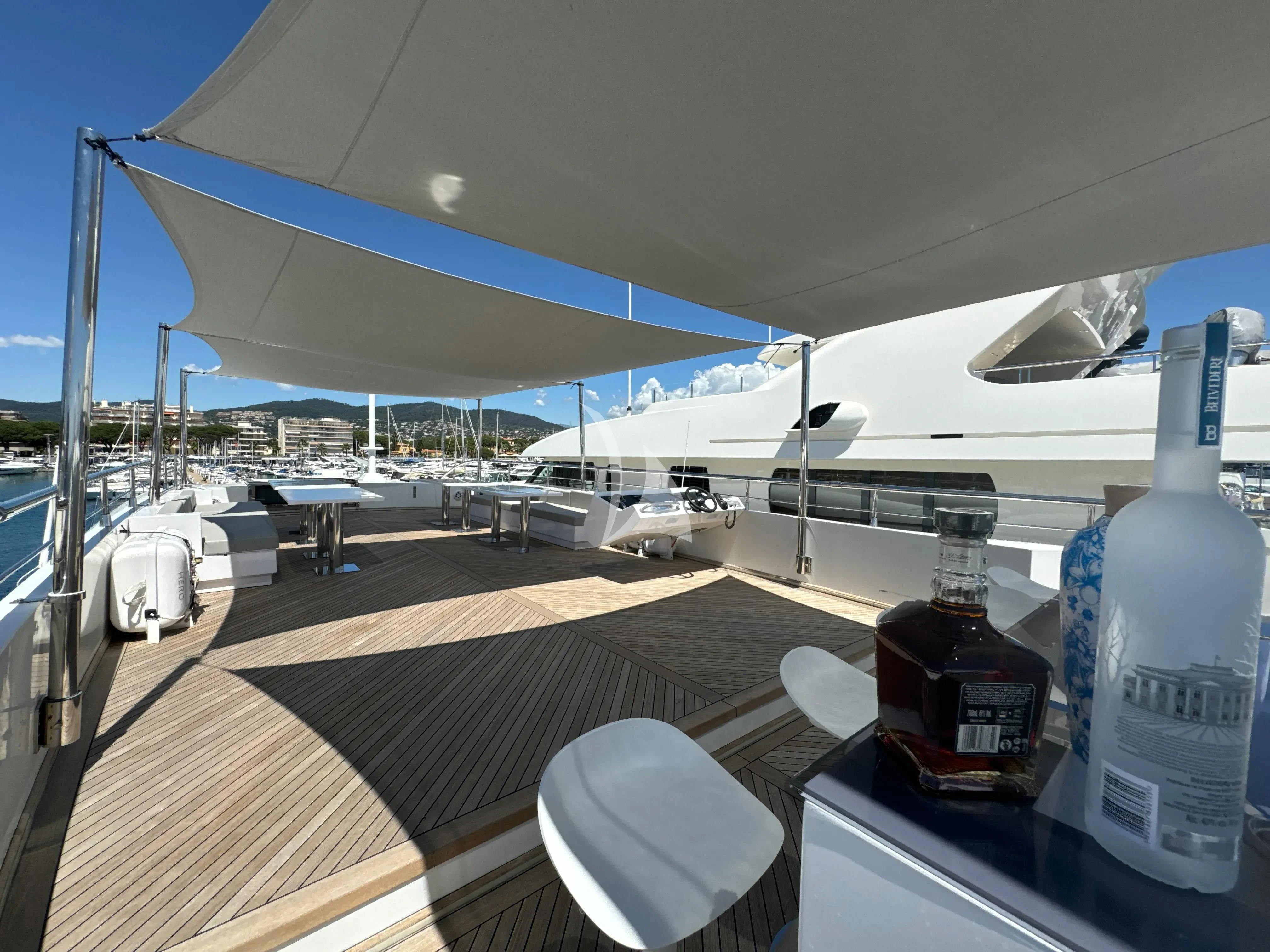 a large white airplane with a table and chairs in front of it aboard FAST & FURIOUS Yacht for Charter