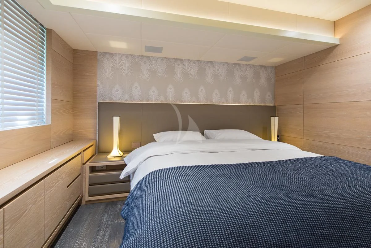 a bed with a blue and white bed spread aboard FAST & FURIOUS Yacht for Charter