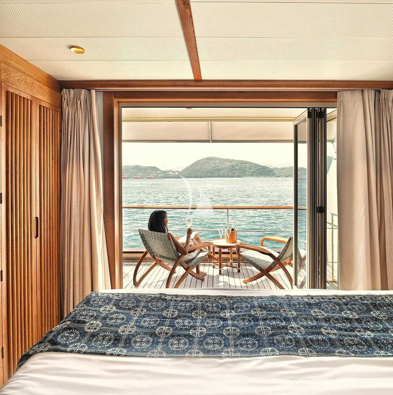 a couple sitting on a bed looking out a window aboard KUDANIL EXPLORER Yacht for Sale