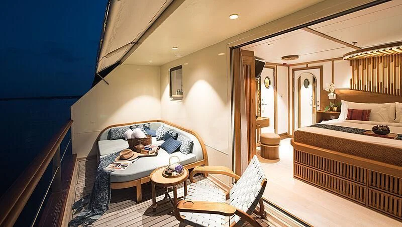a bedroom with a bed and a table aboard KUDANIL EXPLORER Yacht for Sale