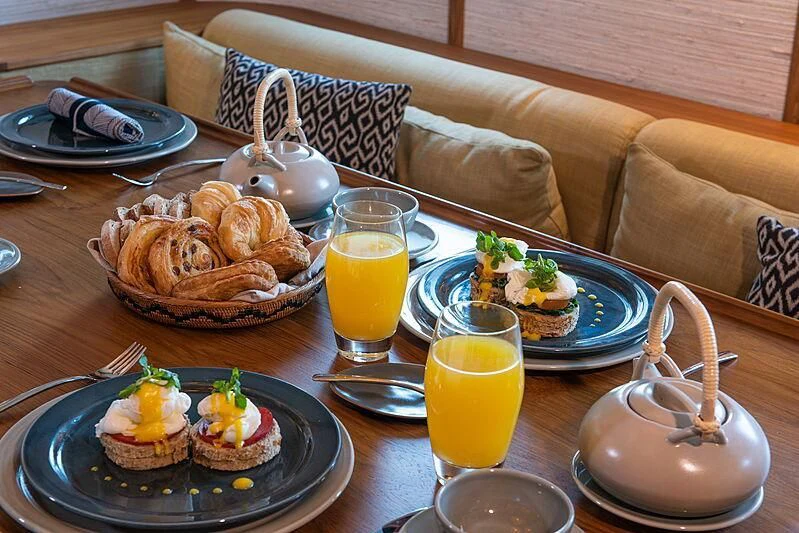 a table with food and drinks on it aboard KUDANIL EXPLORER Yacht for Sale