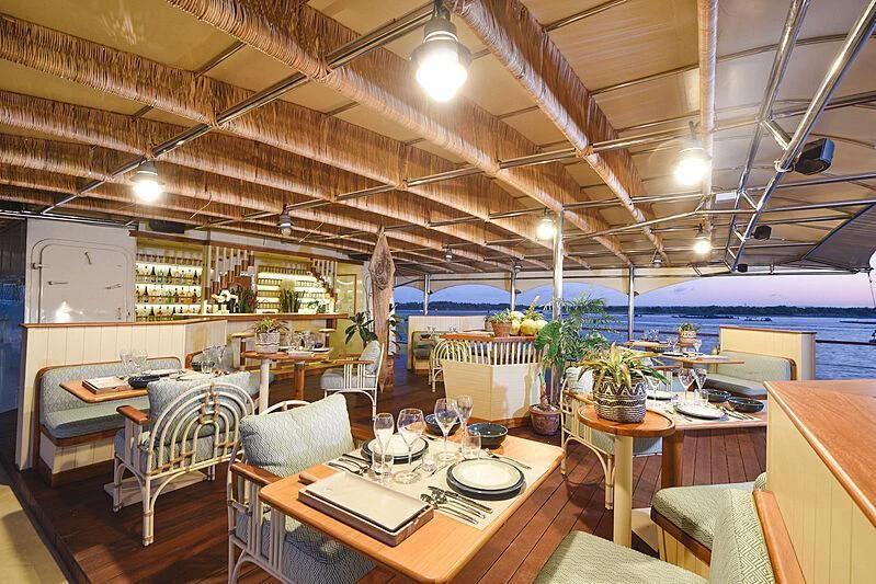a restaurant with tables and chairs aboard KUDANIL EXPLORER Yacht for Sale