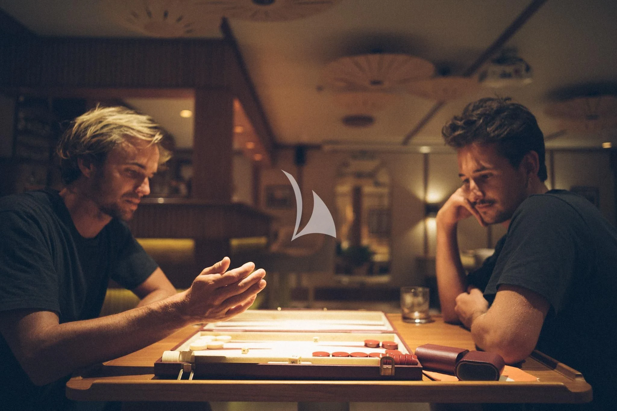 a couple of men sitting at a table playing a game aboard KUDANIL EXPLORER Yacht for Sale