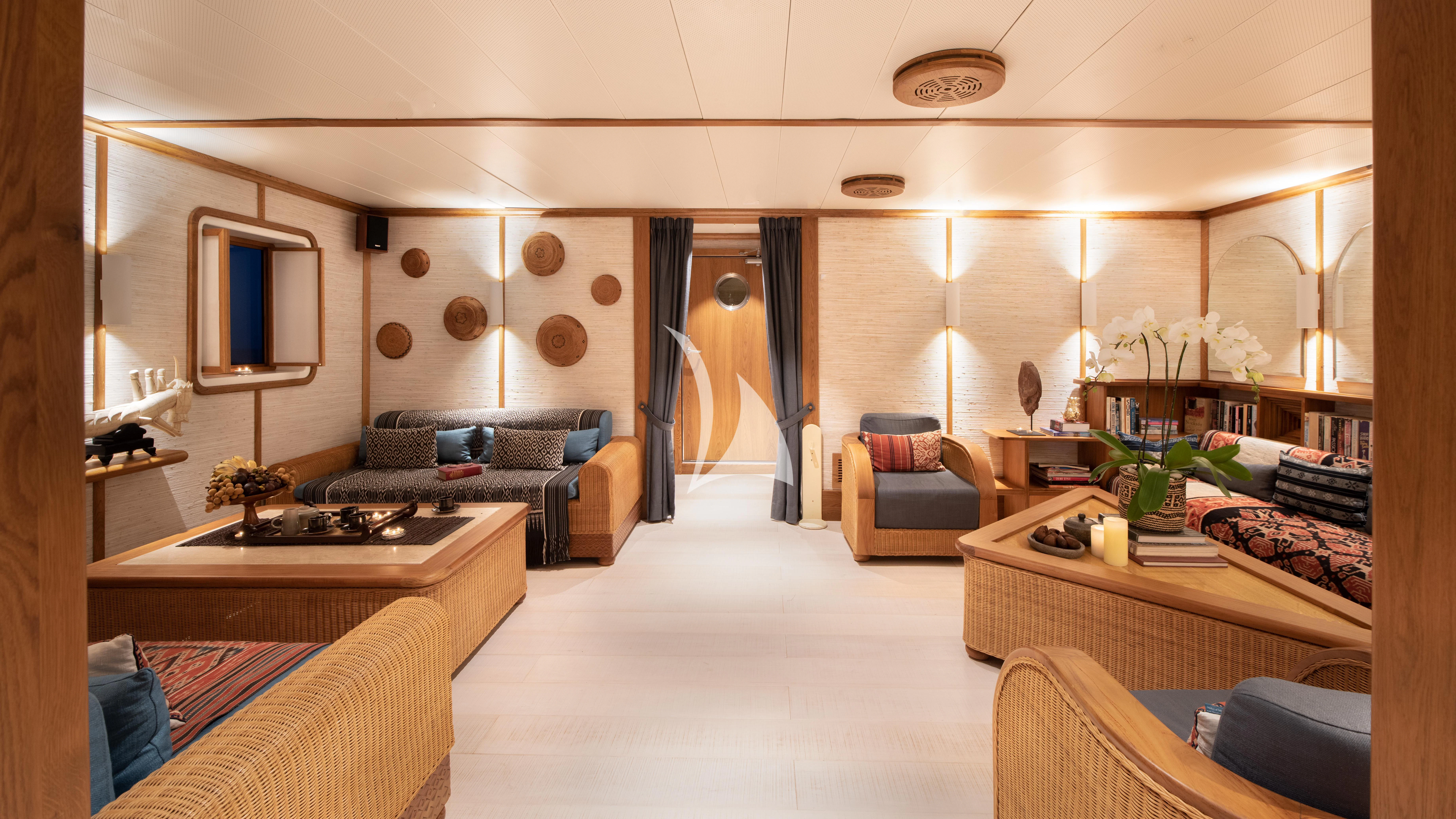 a living room with a couch and a table aboard KUDANIL EXPLORER Yacht for Sale