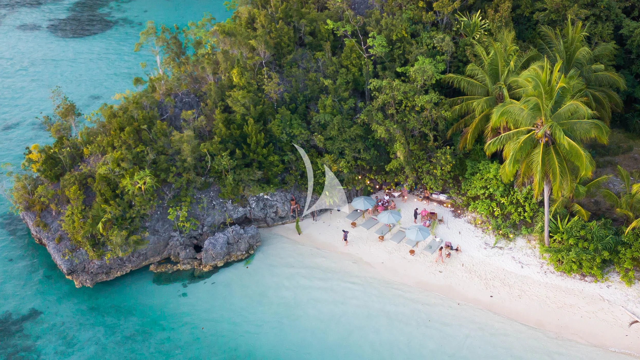 a beach with people and trees aboard KUDANIL EXPLORER Yacht for Sale